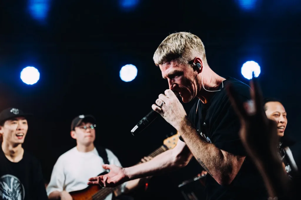 The Lazy Habits singer at the microphone mid-line, the band and the front row around him