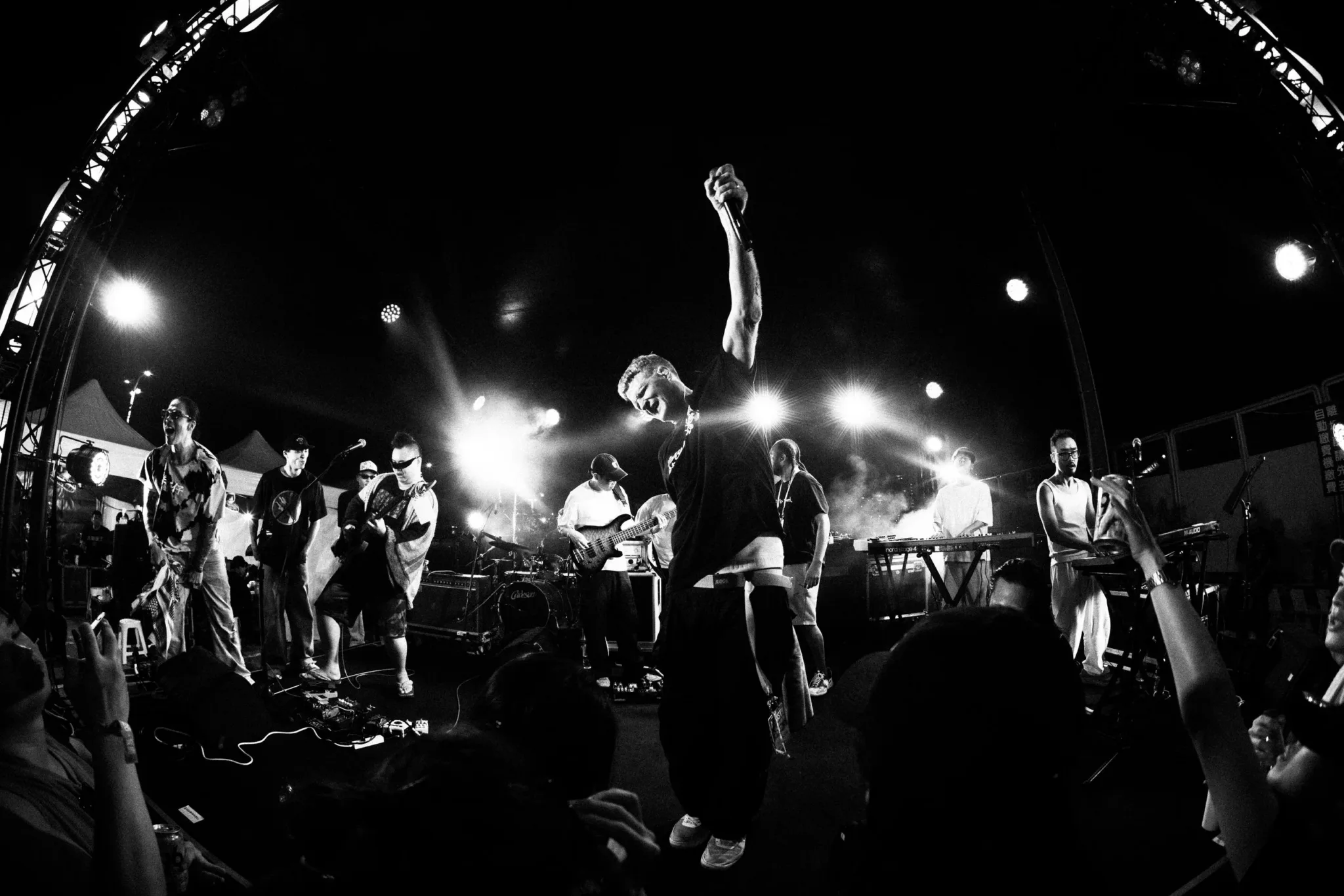 Lazy Habits on stage, shot from the crowd, the singer with one arm raised into the lights