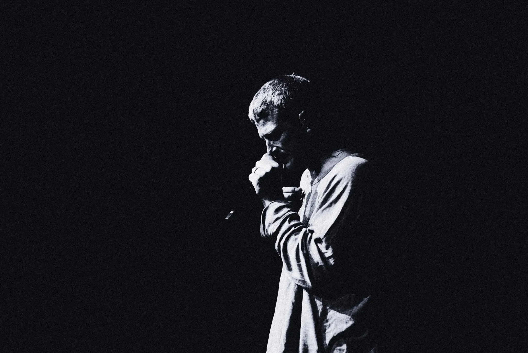 The Lazy Habits singer in profile at the microphone on a dark stage